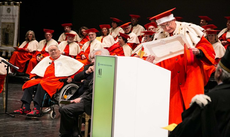 Bertolucci (left, in wheelchair) receiving an honorary degree from the University of Parma