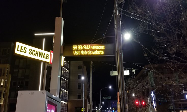 bus stop announcement sign stating to visit the king county website for sr99 route revisions