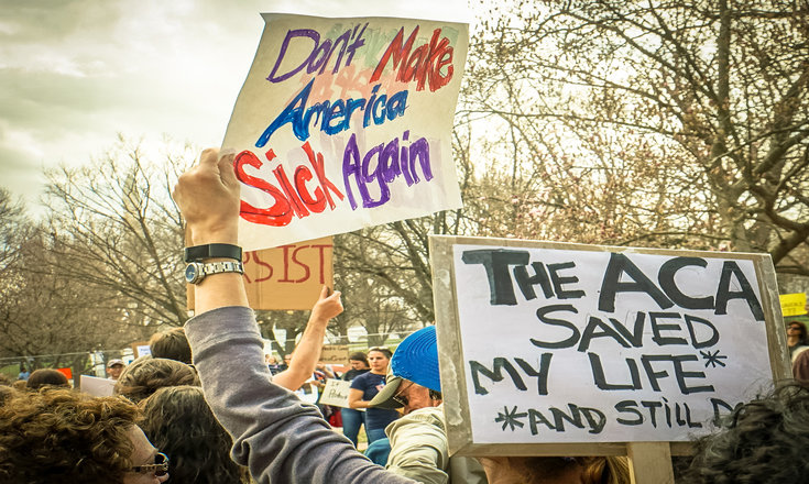 protest signage "don't make america sick again" and "the ACA saved my life"