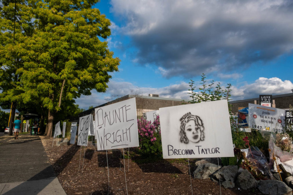 Lawn signs act as tombstones on 23rd Street and Yesler Avenue for those killed by police in recent years.